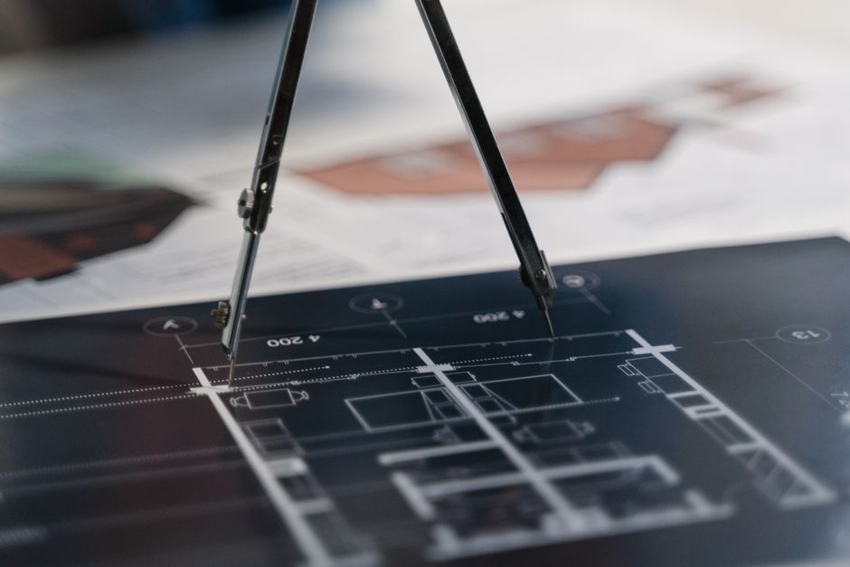 Compas posé sur des plans d'architecte, préparation d'un permis de construire