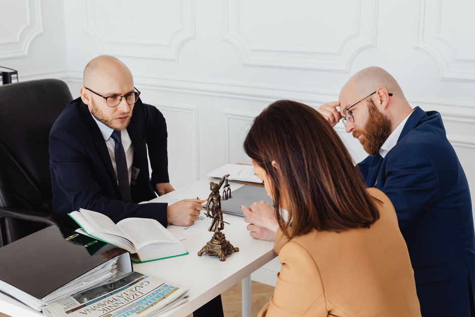 Avocat recevant des particuliers au cabinet pour étudier leur dossier